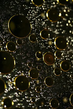 Su siyah zemin üzerinde Bokeh fi ile altın yağ kabarcıkları makro