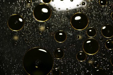 Su siyah zemin üzerinde Bokeh fi ile altın yağ kabarcıkları makro