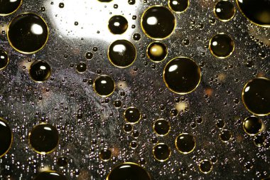 Su siyah zemin üzerinde Bokeh fi ile altın yağ kabarcıkları makro