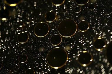 Su siyah zemin üzerinde Bokeh fi ile altın yağ kabarcıkları makro