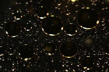 Su siyah zemin üzerinde Bokeh fi ile altın yağ kabarcıkları makro