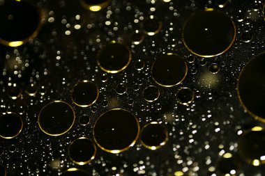 Su siyah zemin üzerinde Bokeh fi ile altın yağ kabarcıkları makro