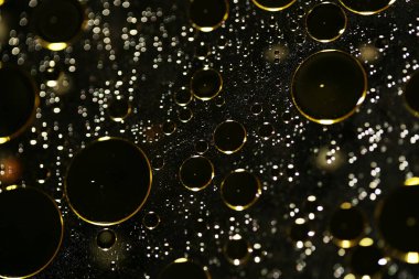 Su siyah zemin üzerinde Bokeh fi ile altın yağ kabarcıkları makro