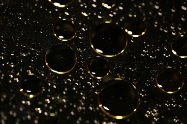 Su siyah zemin üzerinde Bokeh fi ile altın yağ kabarcıkları makro