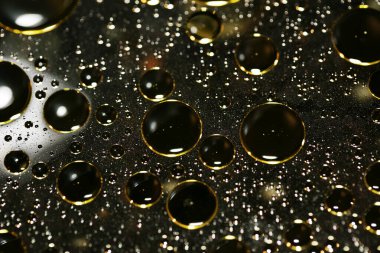 Su siyah zemin üzerinde Bokeh fi ile altın yağ kabarcıkları makro