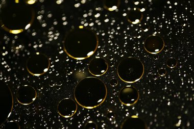 Su siyah zemin üzerinde Bokeh fi ile altın yağ kabarcıkları makro