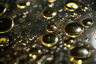 Su siyah zemin üzerinde Bokeh fi ile altın yağ kabarcıkları makro