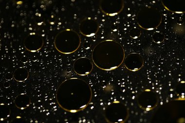 Su siyah zemin üzerinde Bokeh fi ile altın yağ kabarcıkları makro