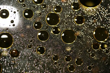 Su siyah zemin üzerinde Bokeh fi ile altın yağ kabarcıkları makro