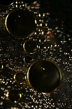 Su siyah zemin üzerinde Bokeh fi ile altın yağ kabarcıkları makro