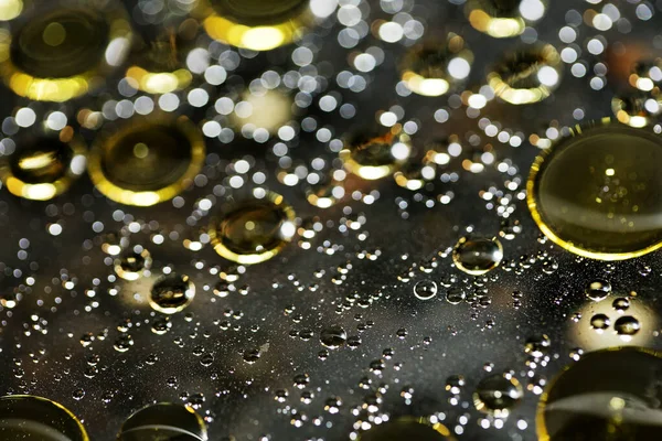 Su siyah zemin üzerinde Bokeh fi ile altın yağ kabarcıkları makro