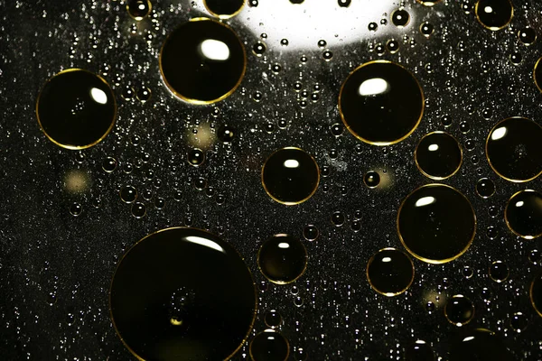 Su siyah zemin üzerinde Bokeh fi ile altın yağ kabarcıkları makro