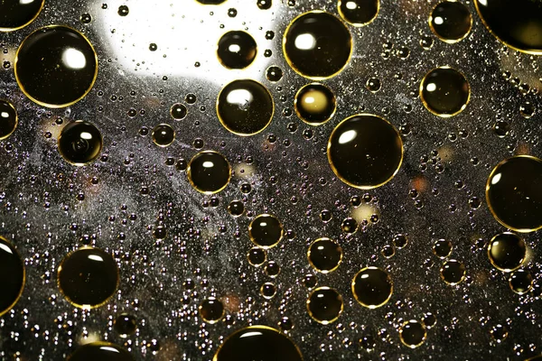 Su siyah zemin üzerinde Bokeh fi ile altın yağ kabarcıkları makro