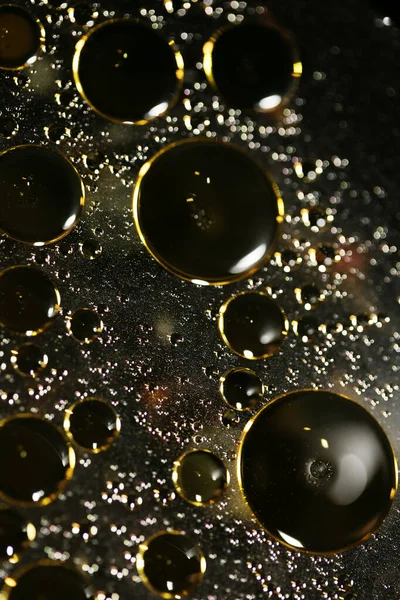 Su siyah zemin üzerinde Bokeh fi ile altın yağ kabarcıkları makro