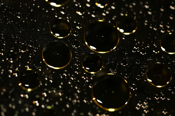 Su siyah zemin üzerinde Bokeh fi ile altın yağ kabarcıkları makro