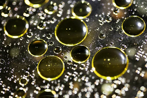 Su siyah zemin üzerinde Bokeh fi ile altın yağ kabarcıkları makro