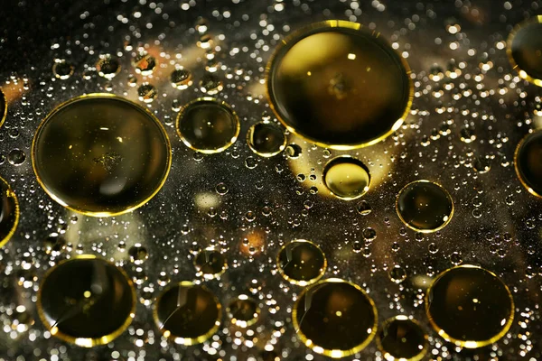 Su siyah zemin üzerinde Bokeh fi ile altın yağ kabarcıkları makro