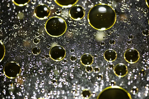 Su siyah zemin üzerinde Bokeh fi ile altın yağ kabarcıkları makro