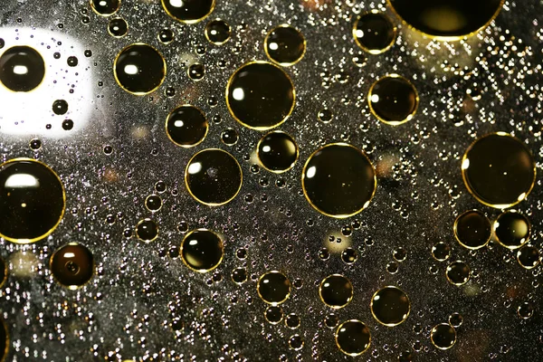 Su siyah zemin üzerinde Bokeh fi ile altın yağ kabarcıkları makro