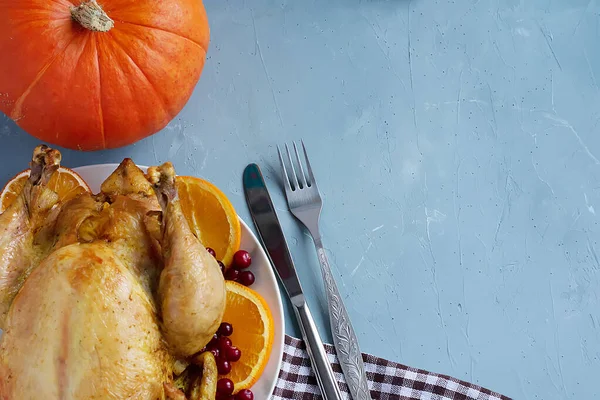 Um prato de frango frito, abóbora, talheres e uma toalha de cozinha xadrez branca e marrom ou guardanapo de algodão estão sobre a mesa. Vista de cima. Copiar espaço para texto. Pode ser usado como um layout para design. Culina — Fotografia de Stock