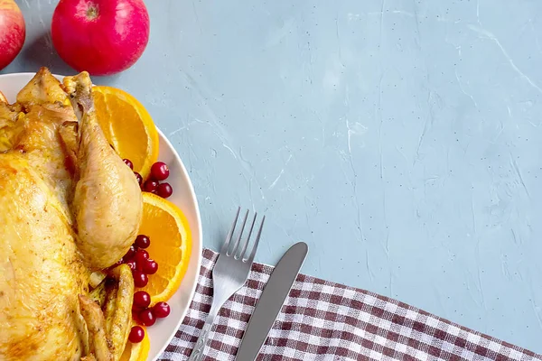 Um prato de frango frito, maçãs, talheres e uma toalha de cozinha quadriculada branca e marrom ou guardanapo de algodão estão sobre a mesa. Vista de cima. Copiar espaço para texto. Pode ser usado como um layout para design. Culinar — Fotografia de Stock