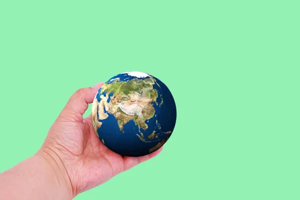 Planet earth in hand on a colored background with place for text. Earth day concept. Ecological problem — Stock Photo, Image