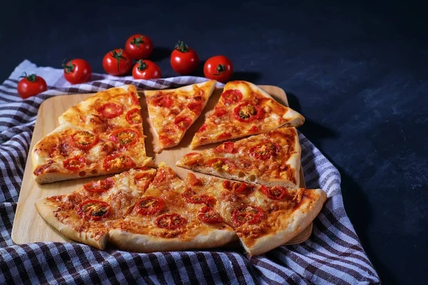 Taze pişmiş ev yapımı pizza Margherita siyah bir arka planda yatıyor.. — Stok fotoğraf