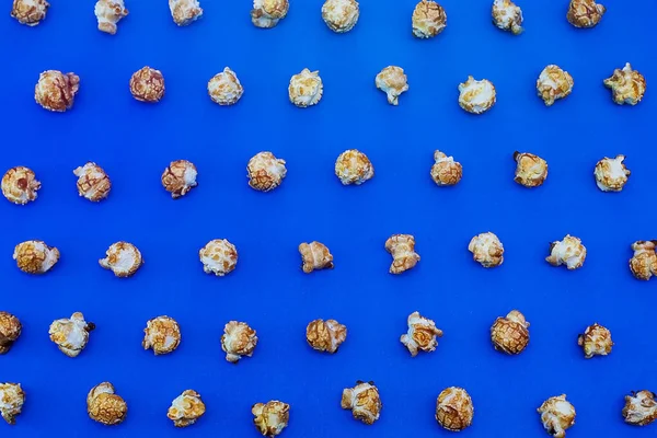 Karamell-Popcorn auf blauem Hintergrund. Filmkonzept. Nahrung zum Filmgucken. Blick von oben. 2020 blaue Hintergrundfarbe — Stockfoto