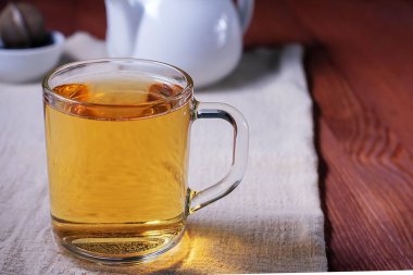 - Çay. Koyu ahşap bir masada çay ve çaydanlık.