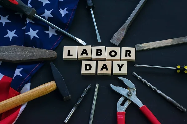 USA Labor Day. Different tools and american flag on a black background — Stock Photo, Image