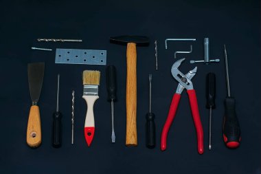 Siyah arka planda çeşitli el yapımı aletlerle yatıyordu. İşçi Bayramı arkaplan kavramı