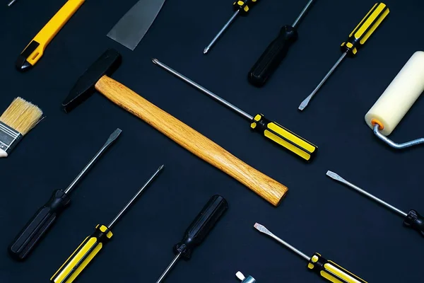 Vlak gelegd met diverse handbouwgereedschap op een zwarte achtergrond. Achtergrond van de arbeidsdag Stockfoto