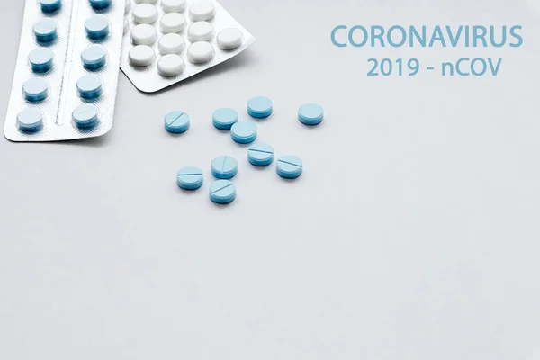 Kék-fehér orvosi tabletták fehér alapon a szó: coronavirus. 2019-ncov. Koronavírus járvány fogalma — Stock Fotó