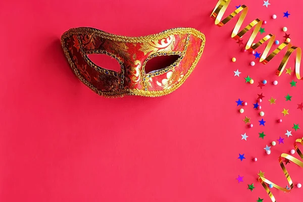 Праздничная маска с декором на красном фоне. Концепция карнавала, Марди Гра, бразильский карнавал, Венецианский карнавал, карнавальный костюм, весна. Плоская кладка, вид сверху, место для текста — стоковое фото