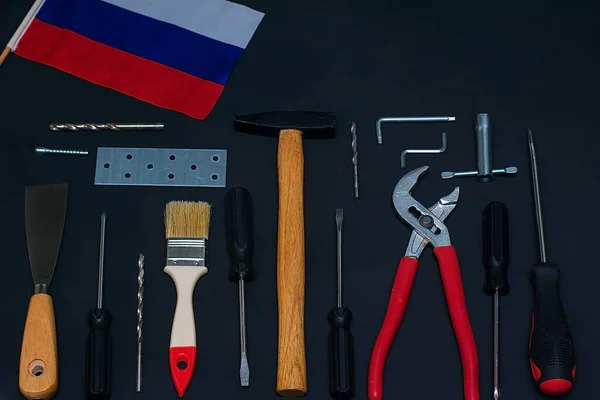 Rusya İşçi Bayramı. Siyah arkaplanda çeşitli araçlar ve bir bayrak
