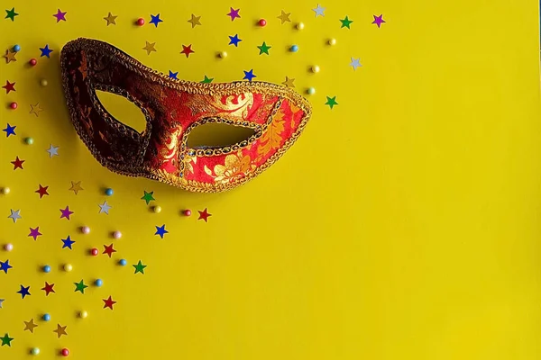 Sarı arka planda dekor olan şölen maskesi. Karnaval kutlaması konsepti, Mardi Gras, Brezilya karnavalı, Venedik karnavalı, karnaval kostümü, bahar. Düz konum, üst görünüm, metin için yer