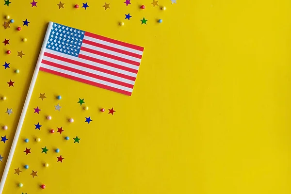 Día de la Independencia de Estados Unidos. Bandera de EE.UU. sobre un fondo amarillo festivo. El concepto de celebración, patriotismo y celebración. Copiar espacio, plano laico — Foto de Stock