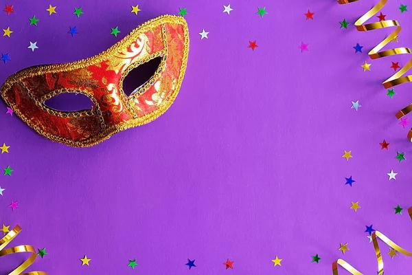 Festliche Maske mit Dekor auf violettem Hintergrund. Karnevalskonzept, mardi gras, brasilianischer Karneval, venezianischer Karneval, Karnevalskostüm, Frühling. flache Liegefläche, Draufsicht, Platz für Text Stockbild