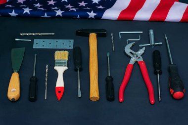 Usa İşçi Bayramı. Siyah arka planda farklı araçlar ve Amerikan bayrağı