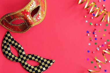 Kırmızı arka planda dekor olan şenlikli maskeler. Karnaval kutlaması konsepti, Mardi Gras, Brezilya karnavalı, Venedik Karnavalı, karnaval kostümü, bahar. Düz konum, üst görünüm, metin için yer.