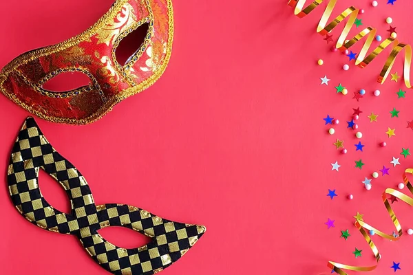 Kırmızı arka planda dekor olan şenlikli maskeler. Karnaval kutlaması konsepti, Mardi Gras, Brezilya karnavalı, Venedik Karnavalı, karnaval kostümü, bahar. Düz konum, üst görünüm, metin için yer.