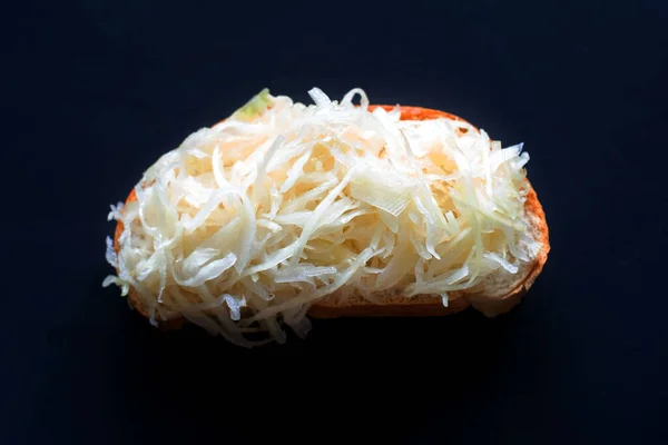 Sandwich of thinly sliced cabbage on a black background, top view, closeup. Vegetarian food — Stock Photo, Image