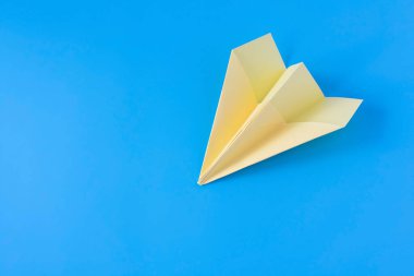 Mavi arka planda sarı kağıt origami düzlemi. Yakın plan..