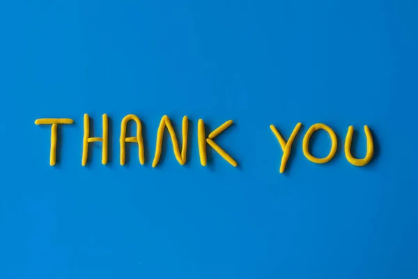 Mavi arkaplandaki kil harflerden gelen sözlere teşekkür ederim. Teşekkürler cümle, teşekkürler kavram, metin ile arka plan.