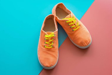 Renkli arka planda parlak turuncu spor ayakkabılar, yakın plan..