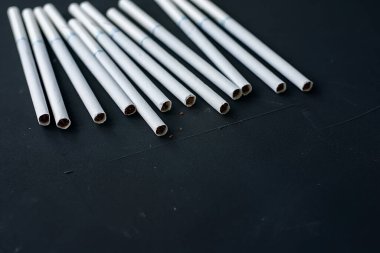 Siyah arkaplanda x filtresi olan beyaz ince sigaralar..