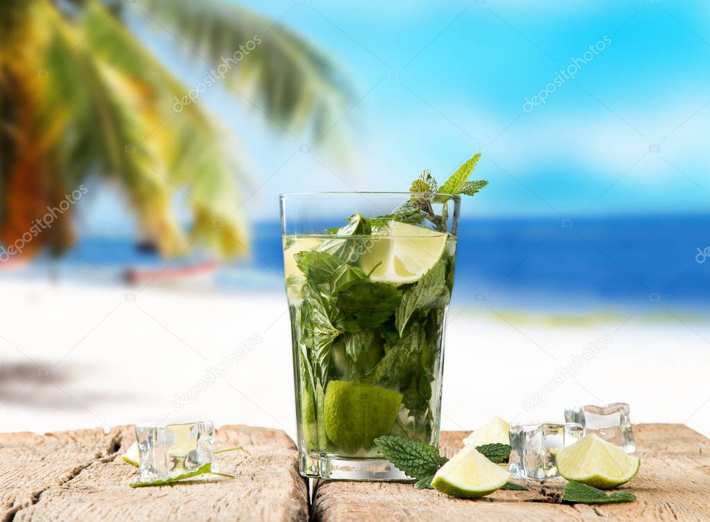 Mohito lime drinks on wooden with blur beach background. Fresh drinks with fruits on wood. Summer concept.