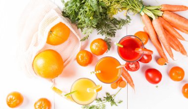 Taze içecekler, meyve suyu domates, portakal ve havuç taze meyve ve sebze ahşap masada. 