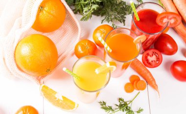 Taze içecekler, meyve suyu domates, portakal ve havuç taze meyve ve sebze ahşap masada. 