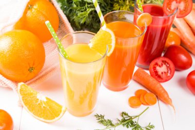 Taze içecekler, meyve suyu domates, portakal ve havuç taze meyve ve sebze ahşap masada. 